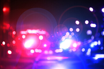 Police red and blue lights in city at night, blurred view