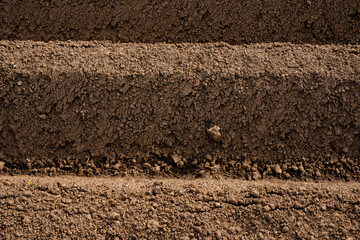 Close-up of a plowed farmland ridge with rich earthy texture and granular soil structure in a cultivated agricultural field