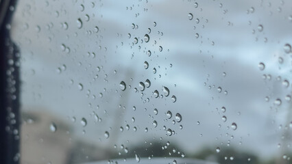 Water droplets clinging to a car window, creating a soft, moody atmosphere after rainfall