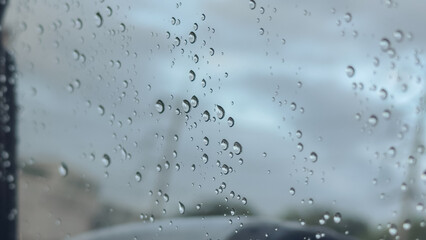 Water droplets clinging to a car window, creating a soft, moody atmosphere after rainfall
