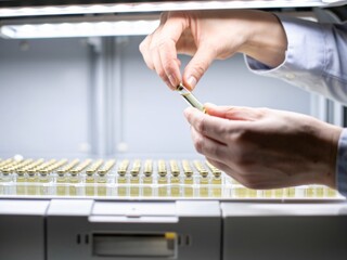 Medical Professional Handling Vial in Laboratory Environment