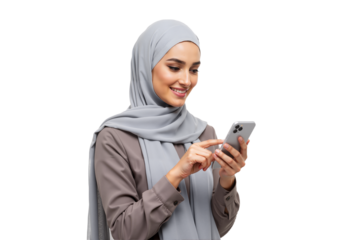 A cheerful Muslim woman wearing a grey hijab happily using a smartphone, isolated on a white studio background.