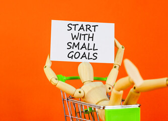 Start with small goals symbol. Concept words phrase Start with small goals on beautiful card. Businessman's model. Beautiful orange paper background. Business Start with small goals concept Copy space © Dzmitry