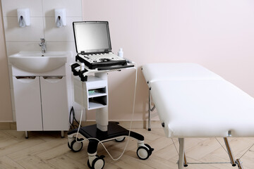 Modern ultrasound machine, sink and examination bed in clinic