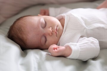 Cute newborn baby sleeping on bed, closeup