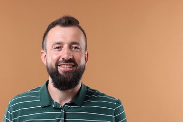 Handsome man laughing on brown background. Space for text