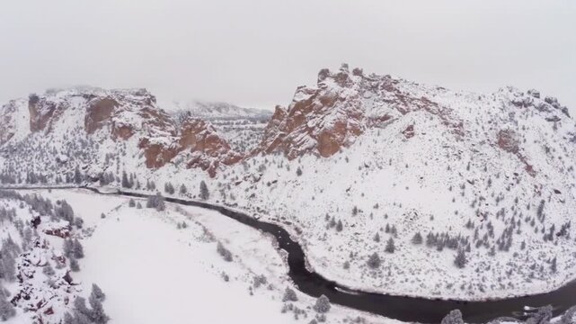 Smith rock state park covered in snow with river flowing through the canyon