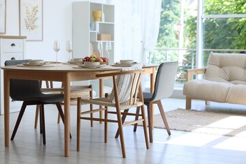 Beautiful table setting, chairs and decor in dining room. Interior design