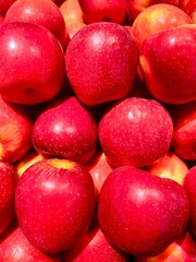 Ripe red apples on a tree at a traditional market stall in Indonesia. A pile of delicious apples. Photographed from close-up.
