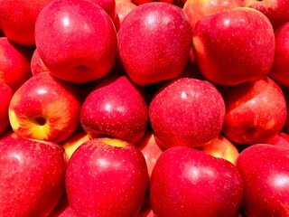 Ripe red apples on a tree at a traditional market stall in Indonesia. A pile of delicious apples. Photographed from close-up.