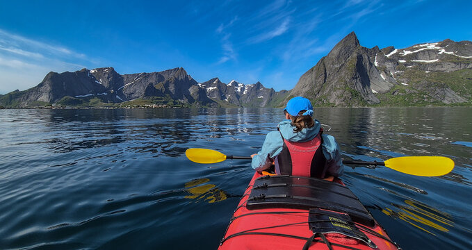 Woman With Kayak On Calm Fjord Near Hamnoy And Reine On Lofoten Islands In Norway