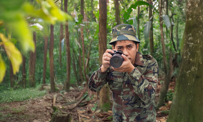 A man in a military uniform is capturing the beauty of nature with a DSLR camera.