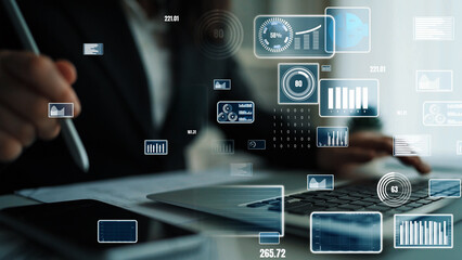 A professional businessman engages in data analysis within an office setting, utilizing technology and visual graphics to aid decision-making and enhance productivity. Xenic