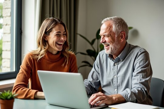 Middle-aged couple bonding over a good laugh while collaborating on a laptop in their warm home workspace.