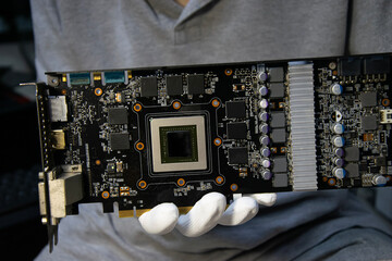 Technician holding a graphics card, computer parts, circuit repair