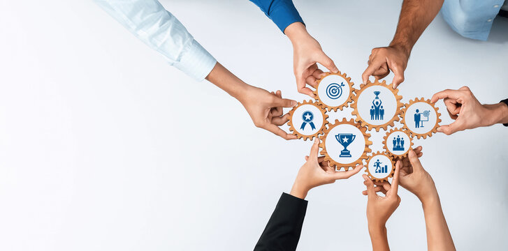 Visual representation of collaboration and teamwork featuring diverse hands working together over gear icons symbolizes strategic planning and achievement goals in business. Amity