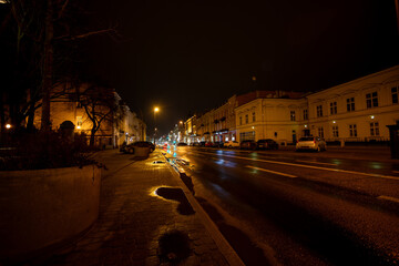 Fototapeta premium A bustling City Street at Night showcasing Glowing Lights and captivating Reflections all around