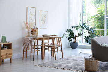 Stylish table setting, chairs, sofa and decor in dining room. Interior design