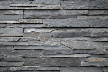 Dark gray stacked stone wall texture background with rough, natural patterns and layered surfaces