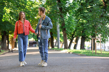 Obraz premium Lovely couple walking together in park, space for text