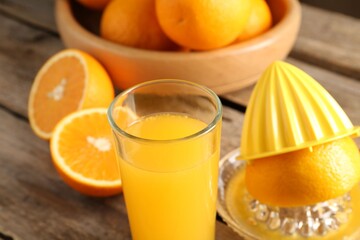 Tasty orange juice, fresh fruits and juicer on wooden table, closeup