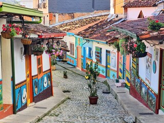 Obraz premium Traditional Colorful colonial houses decorated with colorful bas-relief designs (zocalos) adorning narrow street in guatape, colombia, displaying vivid paint and characteristic architectural charm