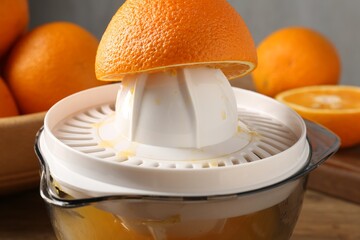 Making juice. Juicer and fresh oranges on table, closeup