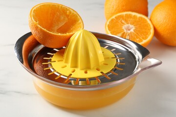 Making juice. Fresh oranges and juicer on white marble table, closeup