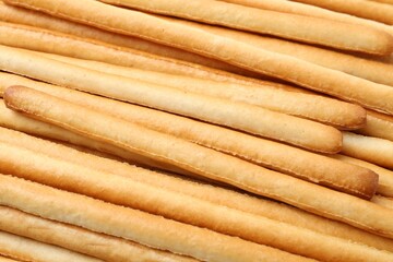 Delicious grissini sticks as background, closeup view