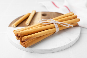 Delicious grissini sticks on white table, closeup