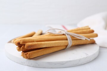 Delicious grissini sticks on white table, closeup