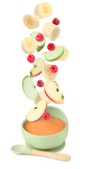Baby food. Raspberries, apple and banana slices falling into bowl of puree on white background