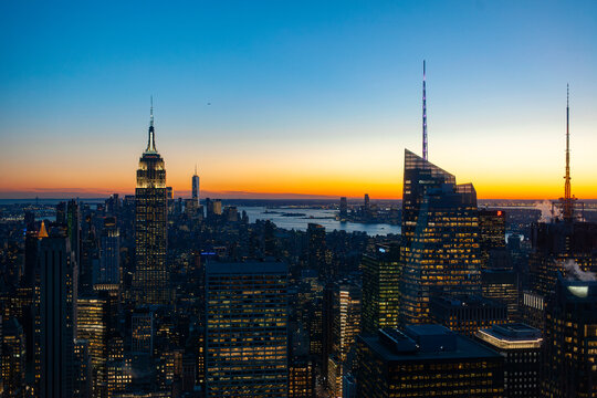 New York City skyline at blue hour with Empire State Building and illuminated office buildings creating urban nightscape - Powered by Adobe