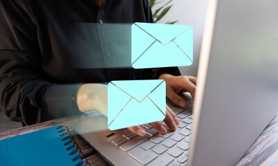 Sending and receiving digital messages. Businesswoman in front of a laptop with floating icons of mail envelopes.