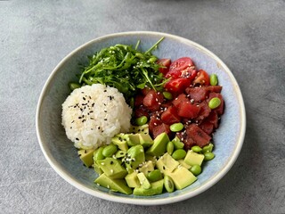Fresh poke bowl with tuna, avocado, rice, and seaweed salad