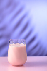 Pink smoothie, vitamin drink, or yogurt on a colorful background.