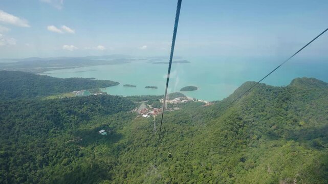 Scenic footage of Malaysia&rsquo;s Langkawi SkyCab, showing cable cars gliding above tropical forest and mountain peaks.