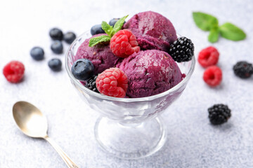 Delicious sorbet with fresh berries and mint in dessert bowl on grey textured table, closeup