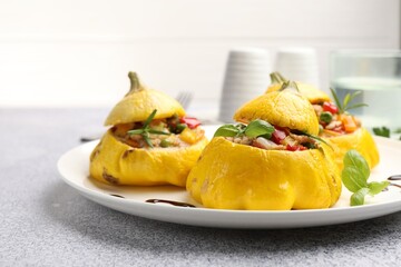 Tasty stuffed pattypan squashes on grey table, closeup