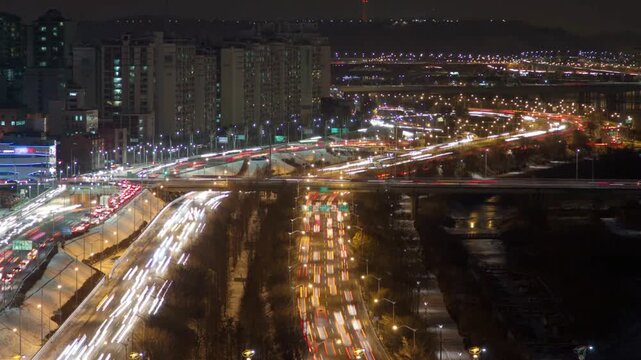 Night view of city traffic with lights on the road and buildings in the background
