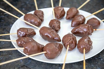 The most perfect sweet in the world, the iconic dessert strawberry of love on a stick, fresh strawberry, powdered milk brigadeiro and red caramel topping. Morango do amor