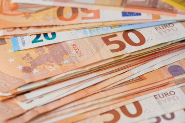 Currency notes stacked on a surface showing euro denominations clearly
