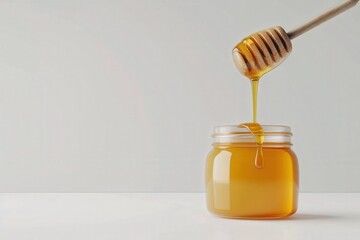 Isolated honey jar with viscous honey dripping from dipper on seamless white surface