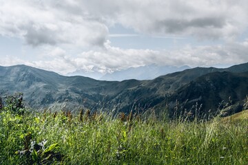 Mountain landscape with green summer meadow and cloudy sky in Saalbach, Austria