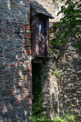An outdoor wooden toilet on the castle wall.
