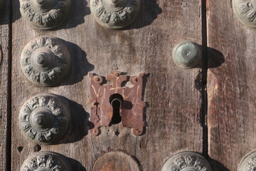 detail of antique door with lock and decorative studs in granada spain