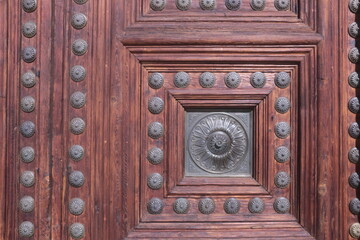 detail of an old wooden church door with metal studs in granada spain