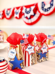 Patriotic decoration. Festive patriotic goody bags with USA-themed decor and star tags displayed on table at Fourth of July or Memorial Day party event