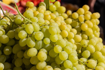 Fresh green grapes displayed at a local market in bright sunlight during the afternoon