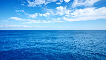 Fototapeta premium Tranquil expanse of deep blue ocean meeting a vast, cloud-filled sky.